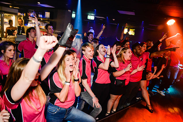 a group of netball team cheering and partying in cocktails nightclub , on the down under party tour